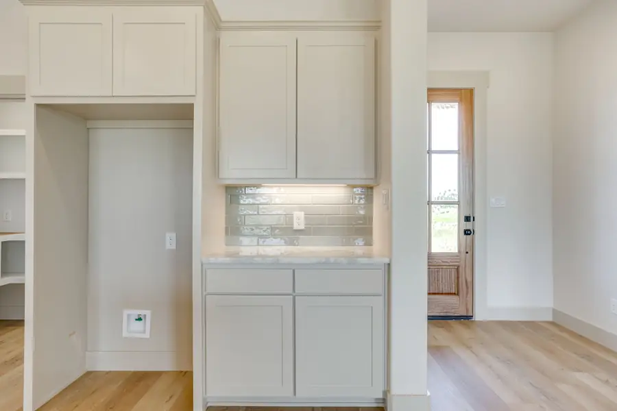 Built-in kitchen cabinetry with light gray tile backsplash