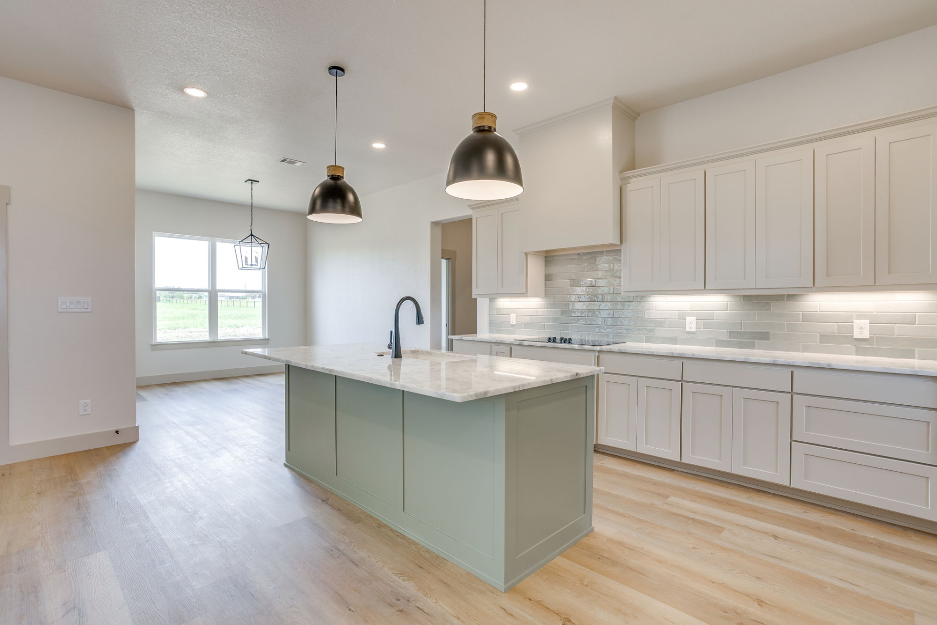 Kitchen island with marble countertops and black pendant lights