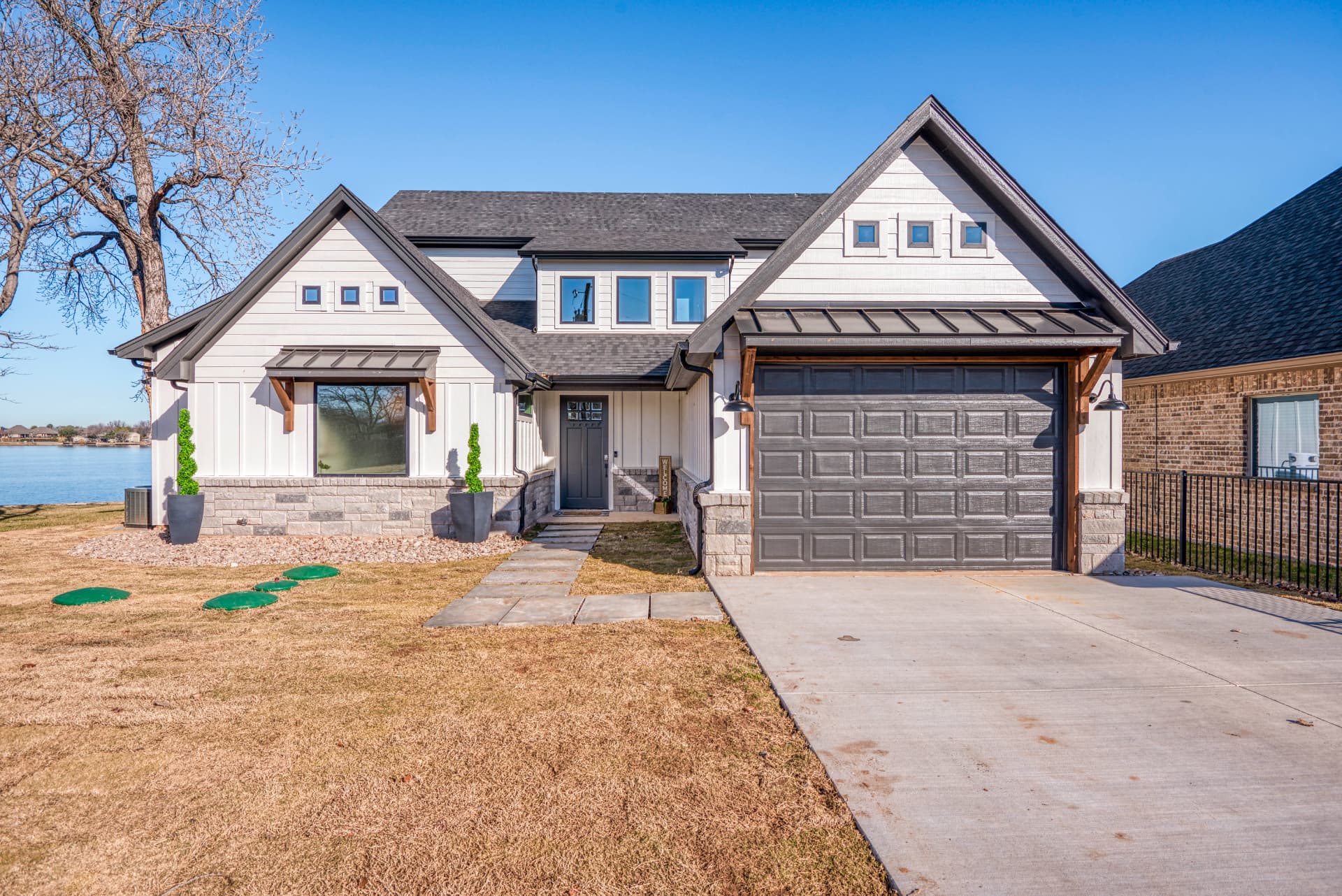 Front elevation with driveway, garage, and manicured lawn