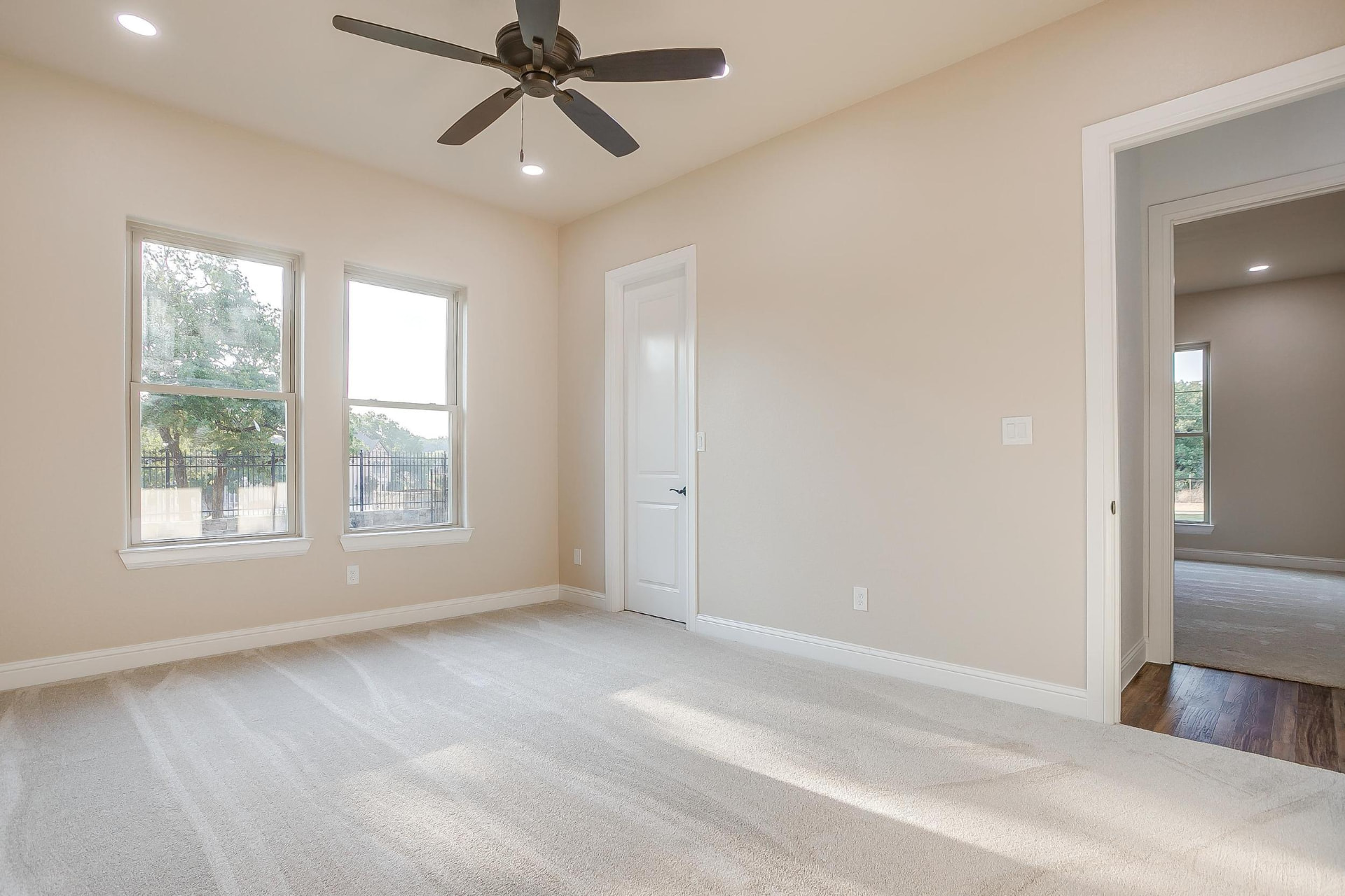 Bedroom with three large windows and carpet