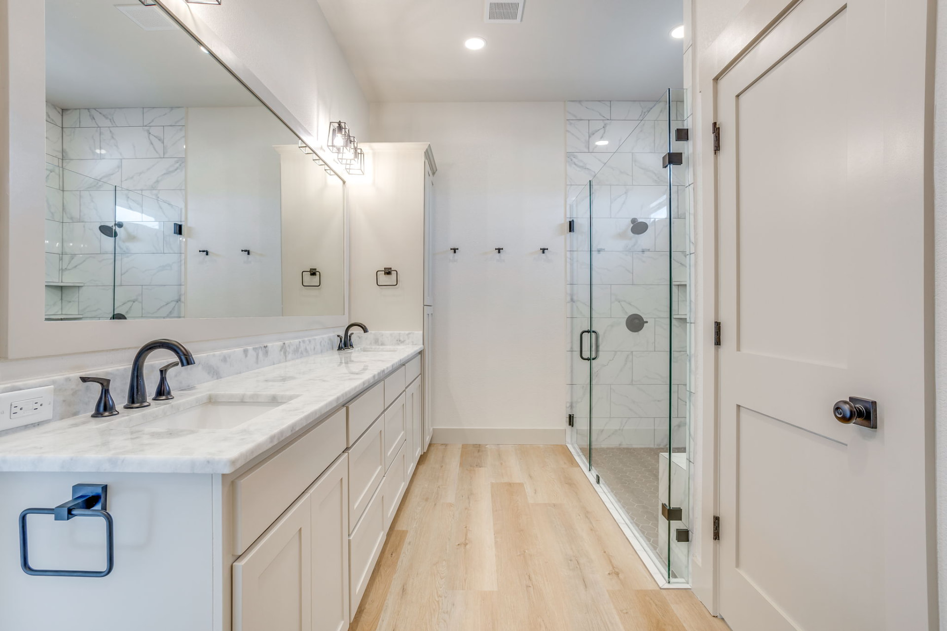 Primary bath with double vanity and glass-enclosed walk-in shower