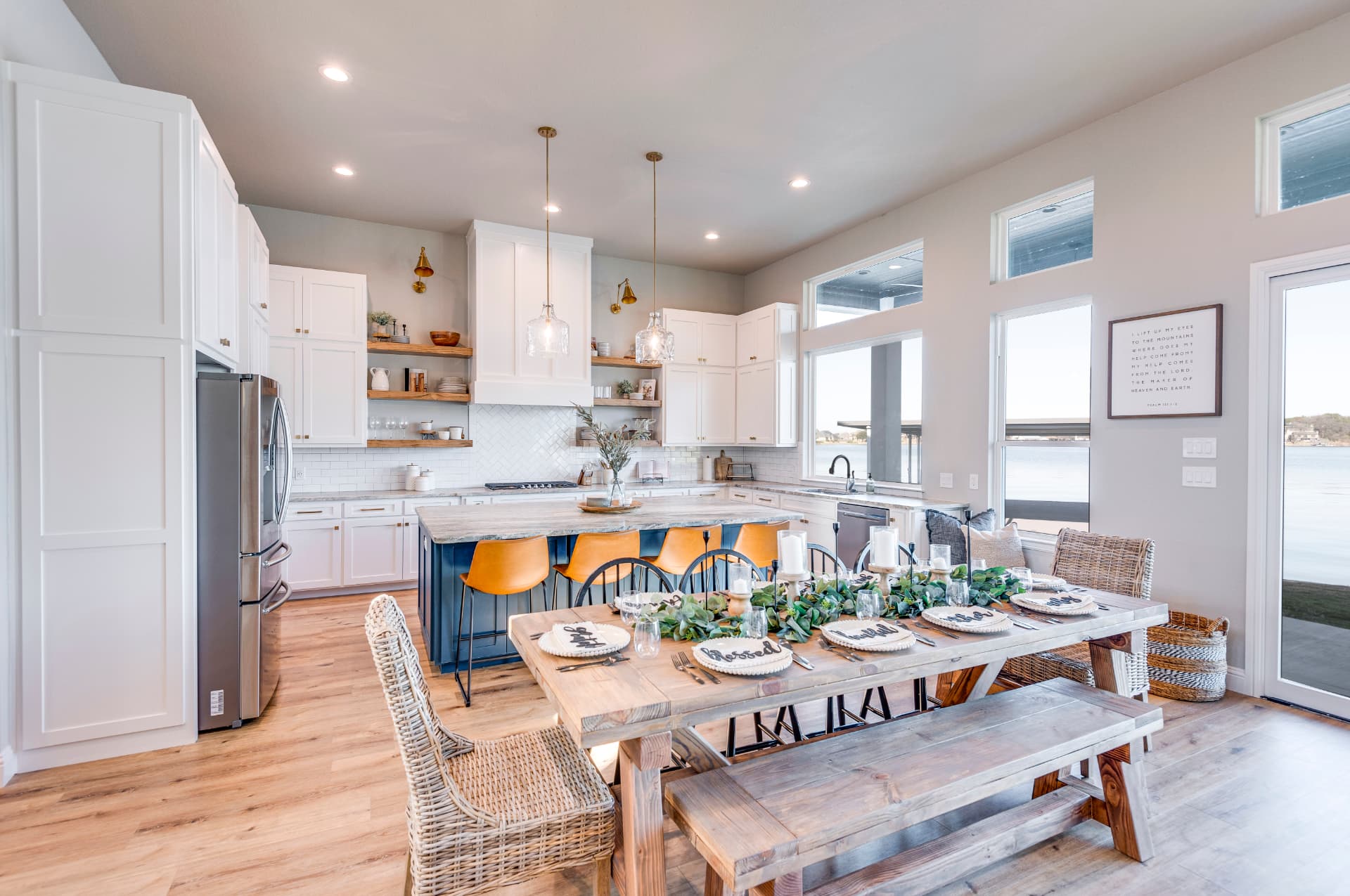 Dining area with a long wood table and navy kitchen island beyond