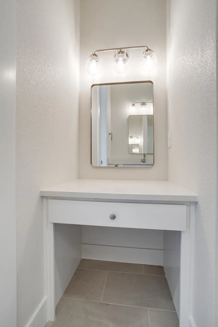 Built-in makeup vanity nook with a lit mirror