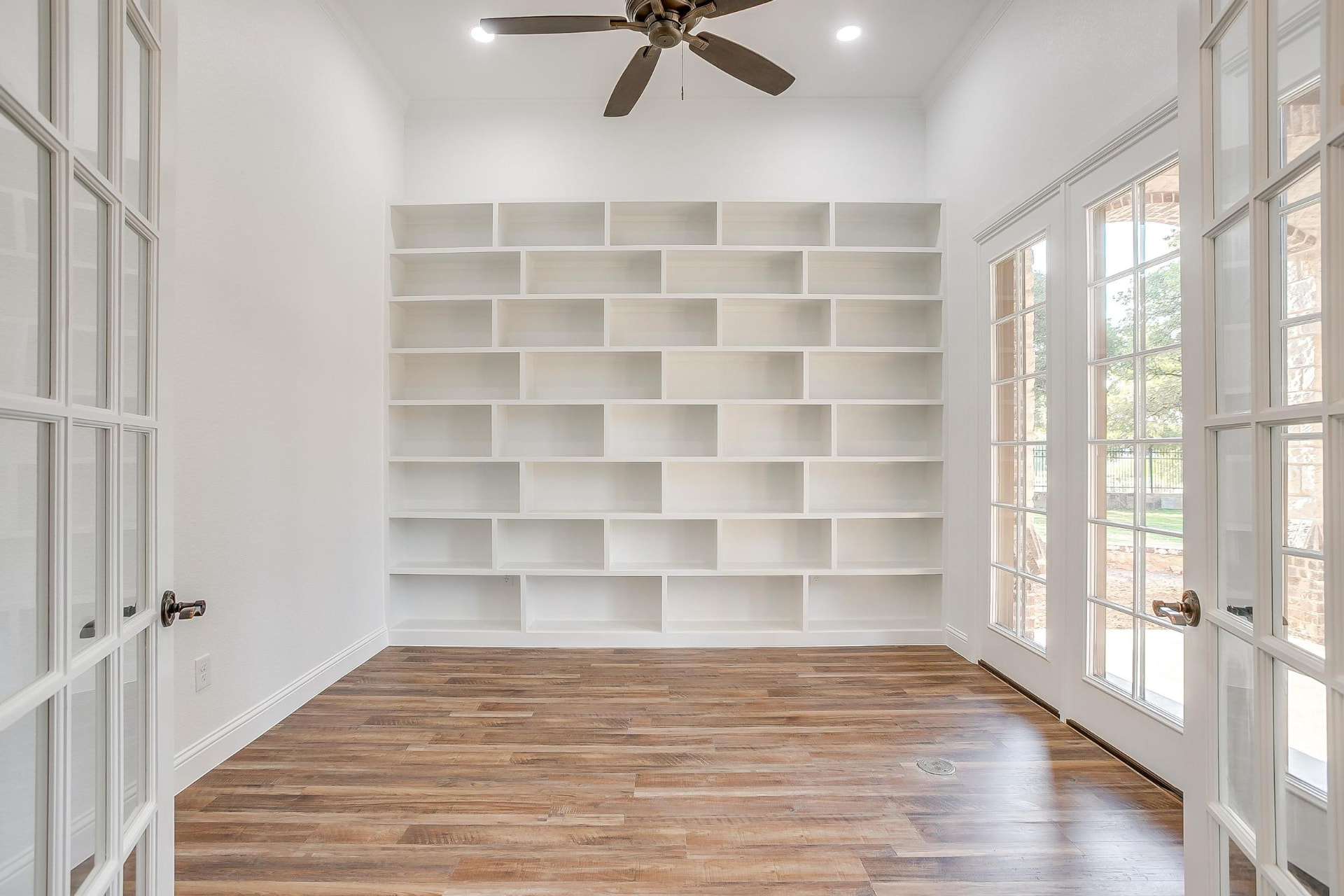 Built-in library wall with floor-to-ceiling white shelving