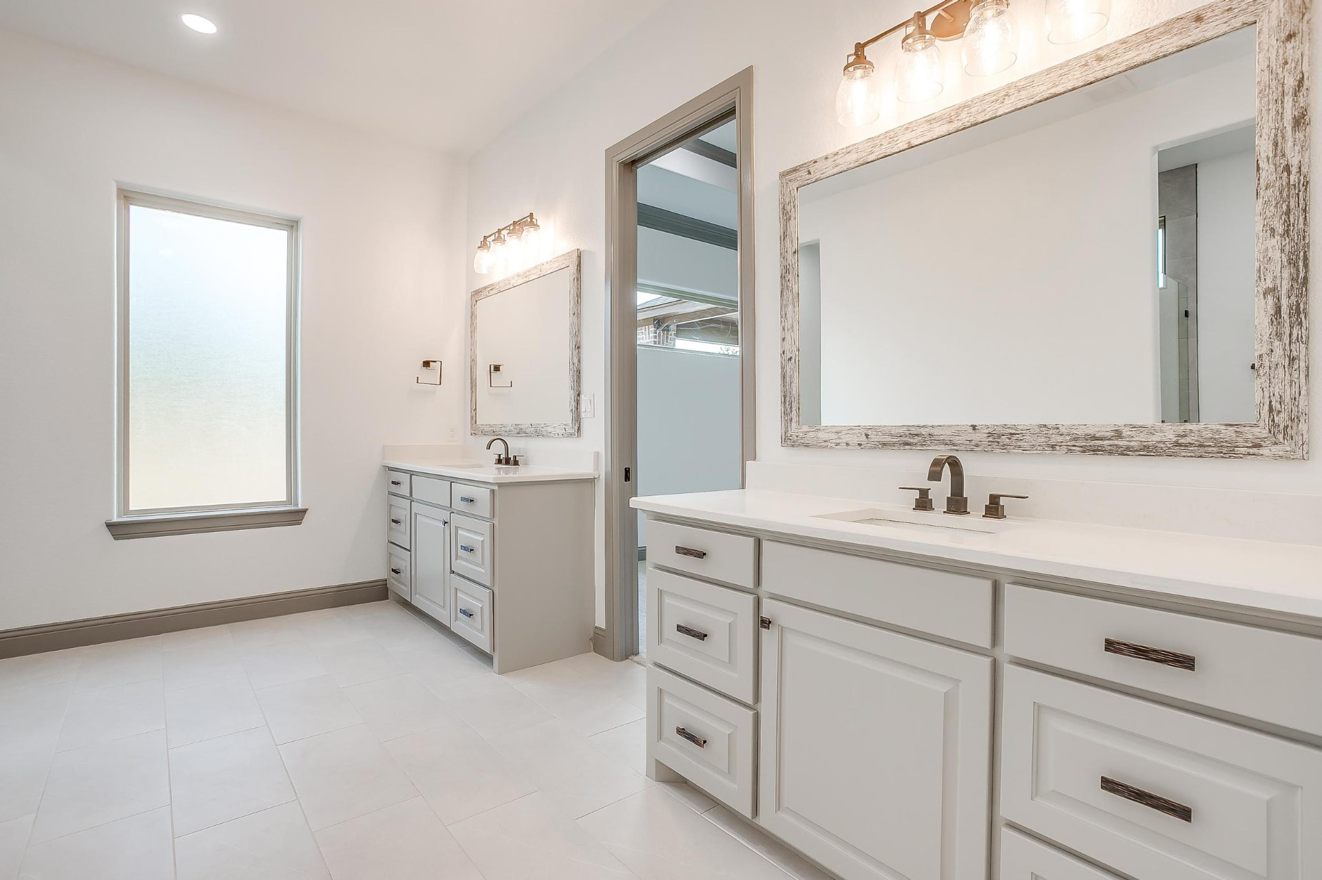 Dual primary vanities with rustic wood-framed mirrors