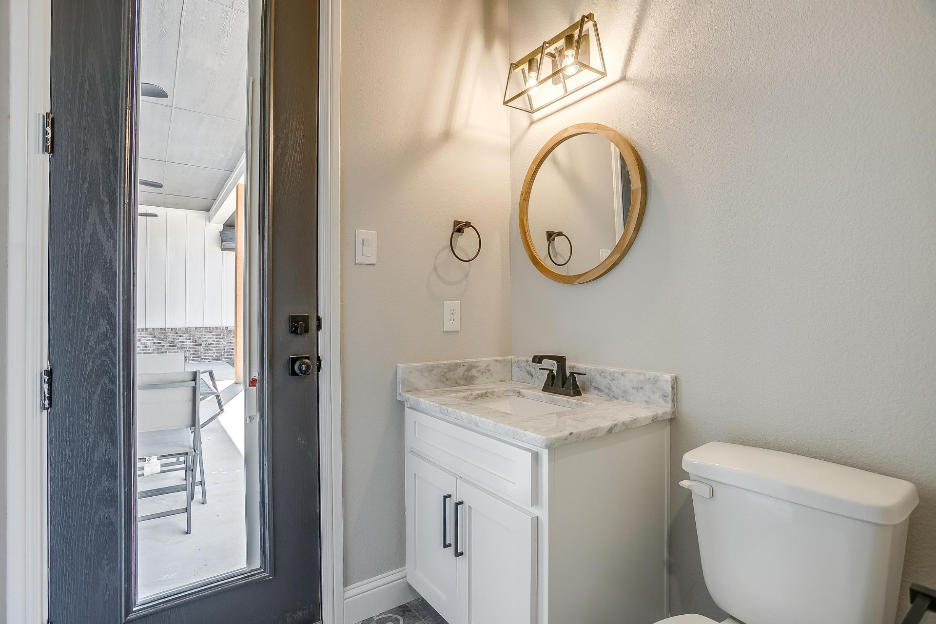 Powder room with white vanity and brass light fixture