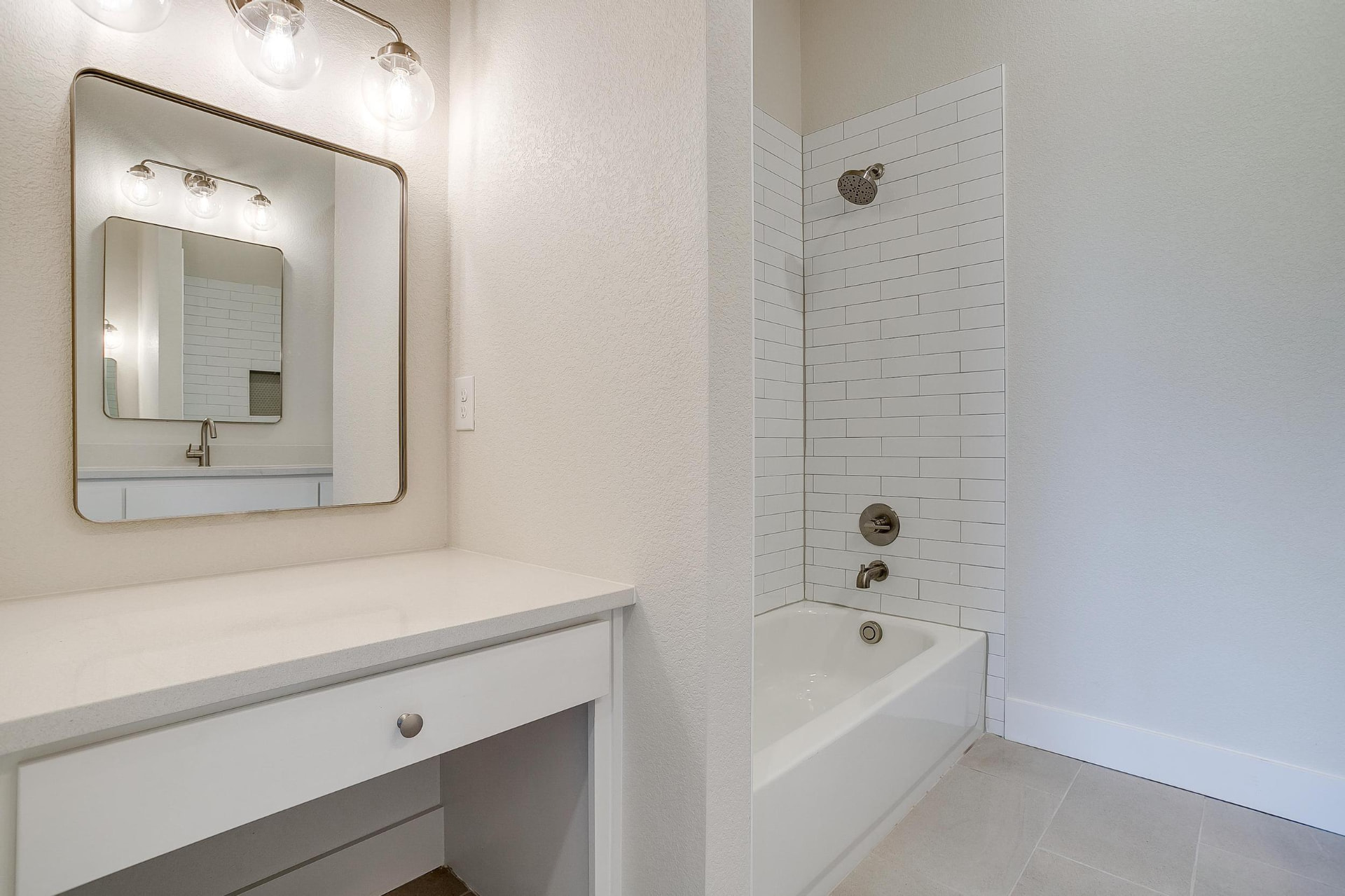 Bath with a built-in makeup vanity and tiled tub surround