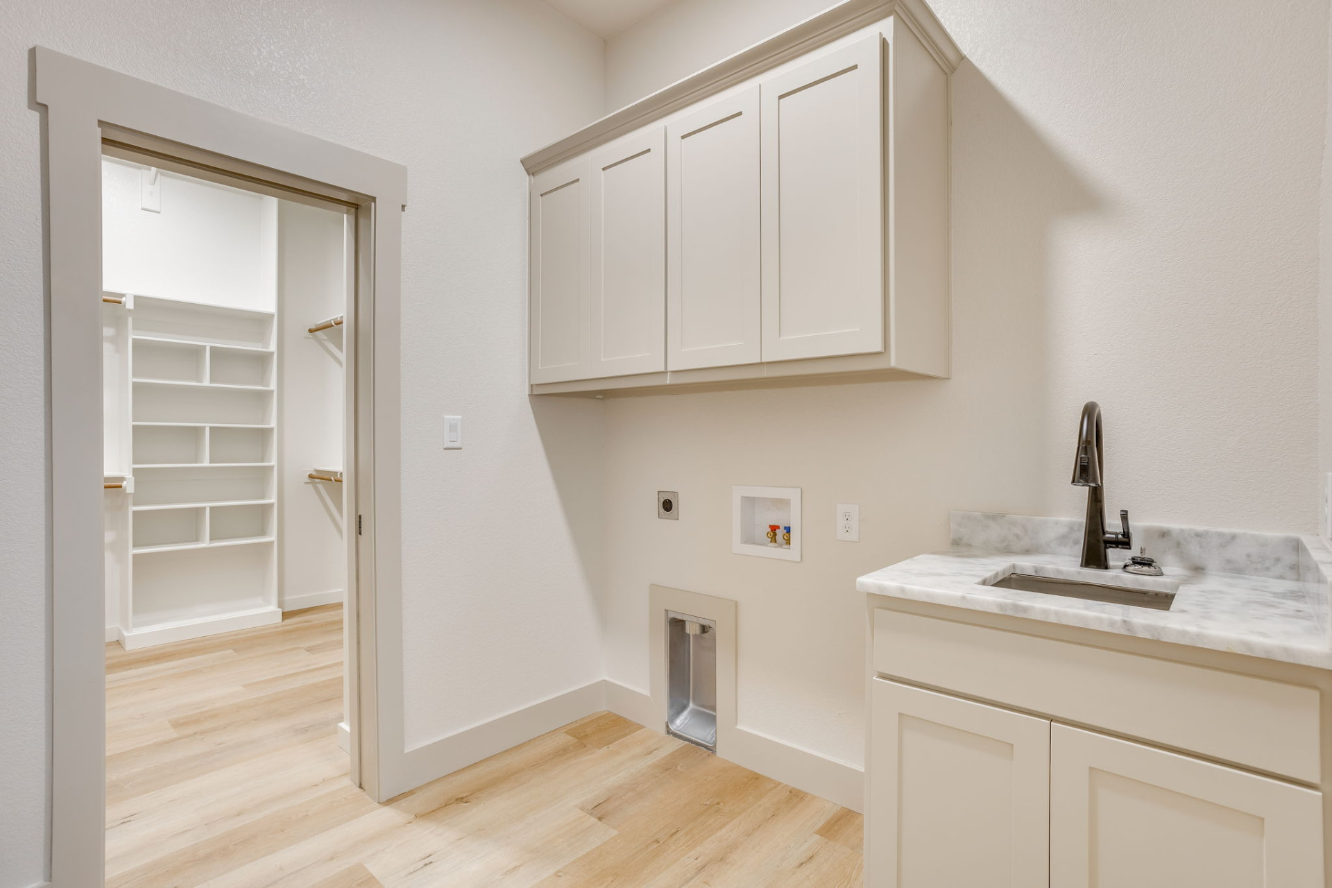 Laundry room with gray cabinets and a utility sink
