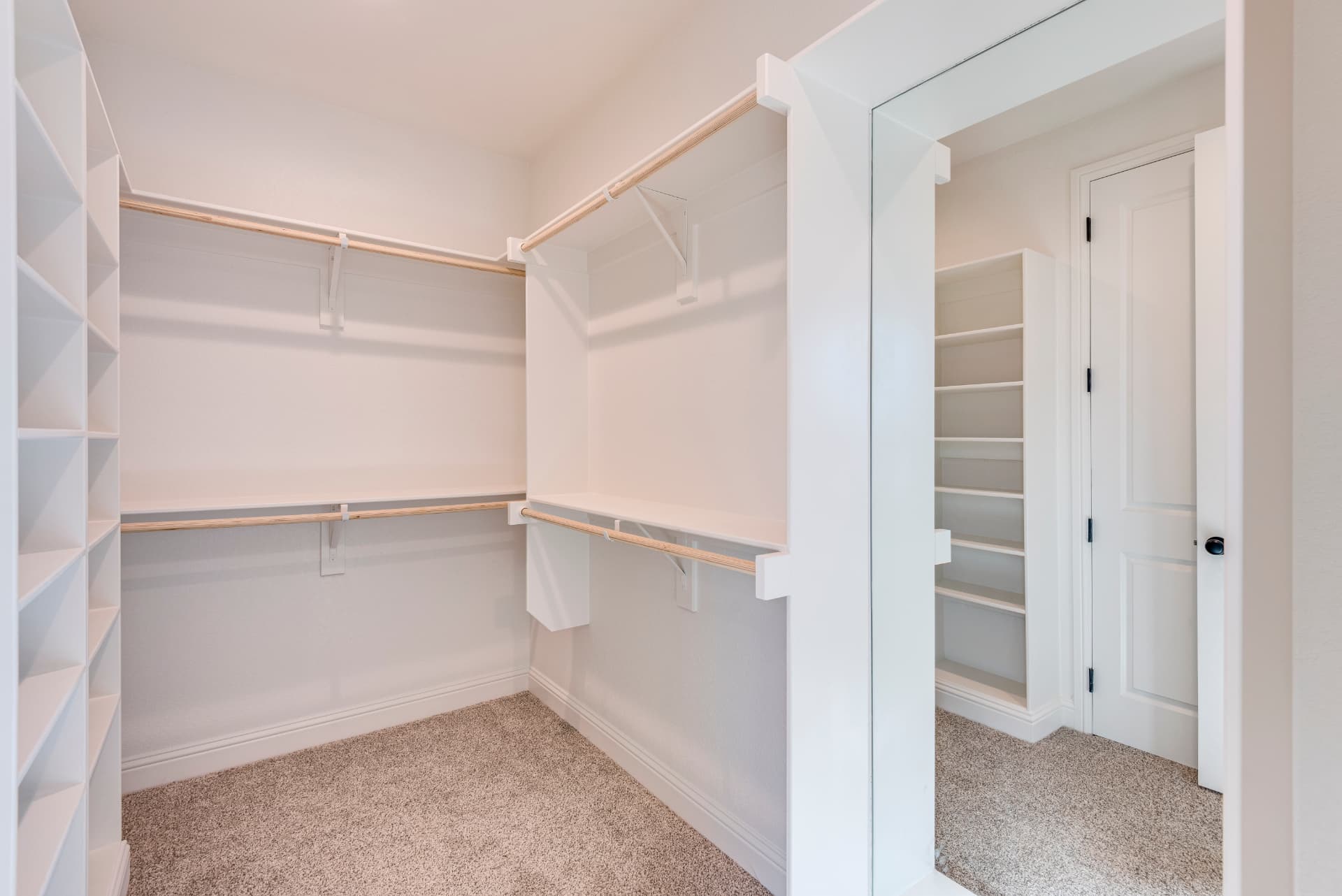 Walk-in closet with built-in white shelving and drawers