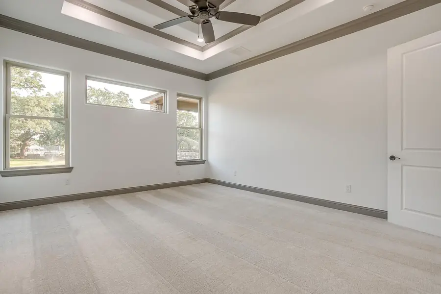 Wide view of the carpeted primary bedroom