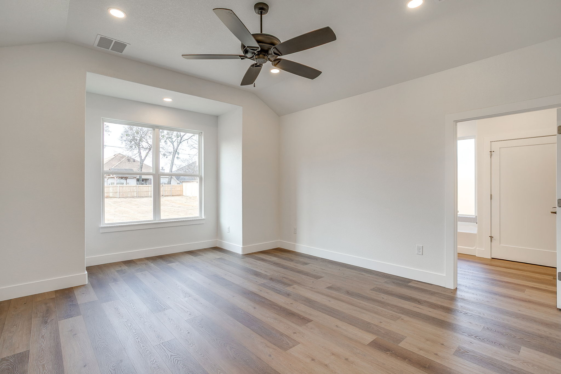Primary suite with bay window overlooking the yard