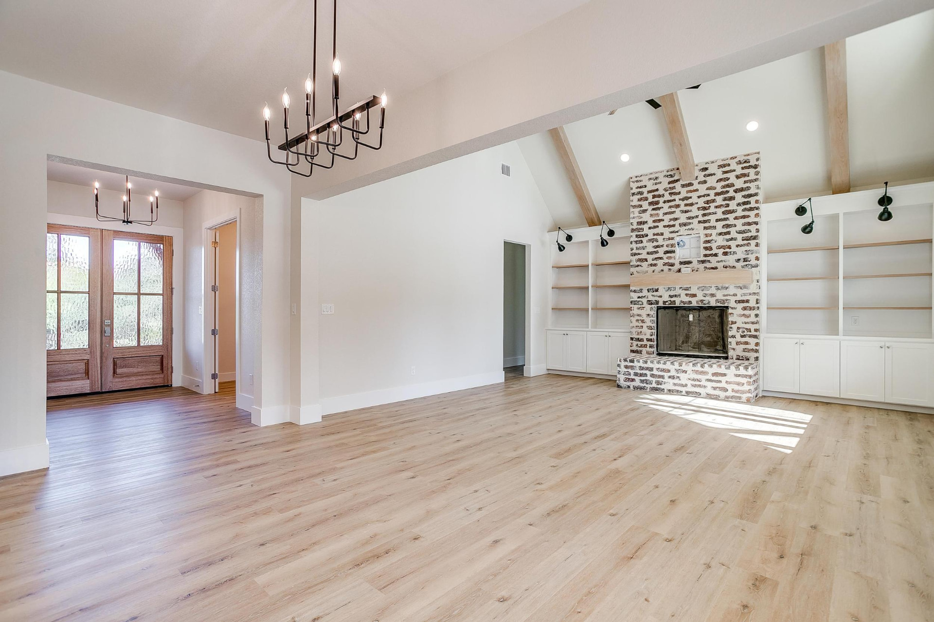 Foyer view into the main living space with the brick fireplace beyond
