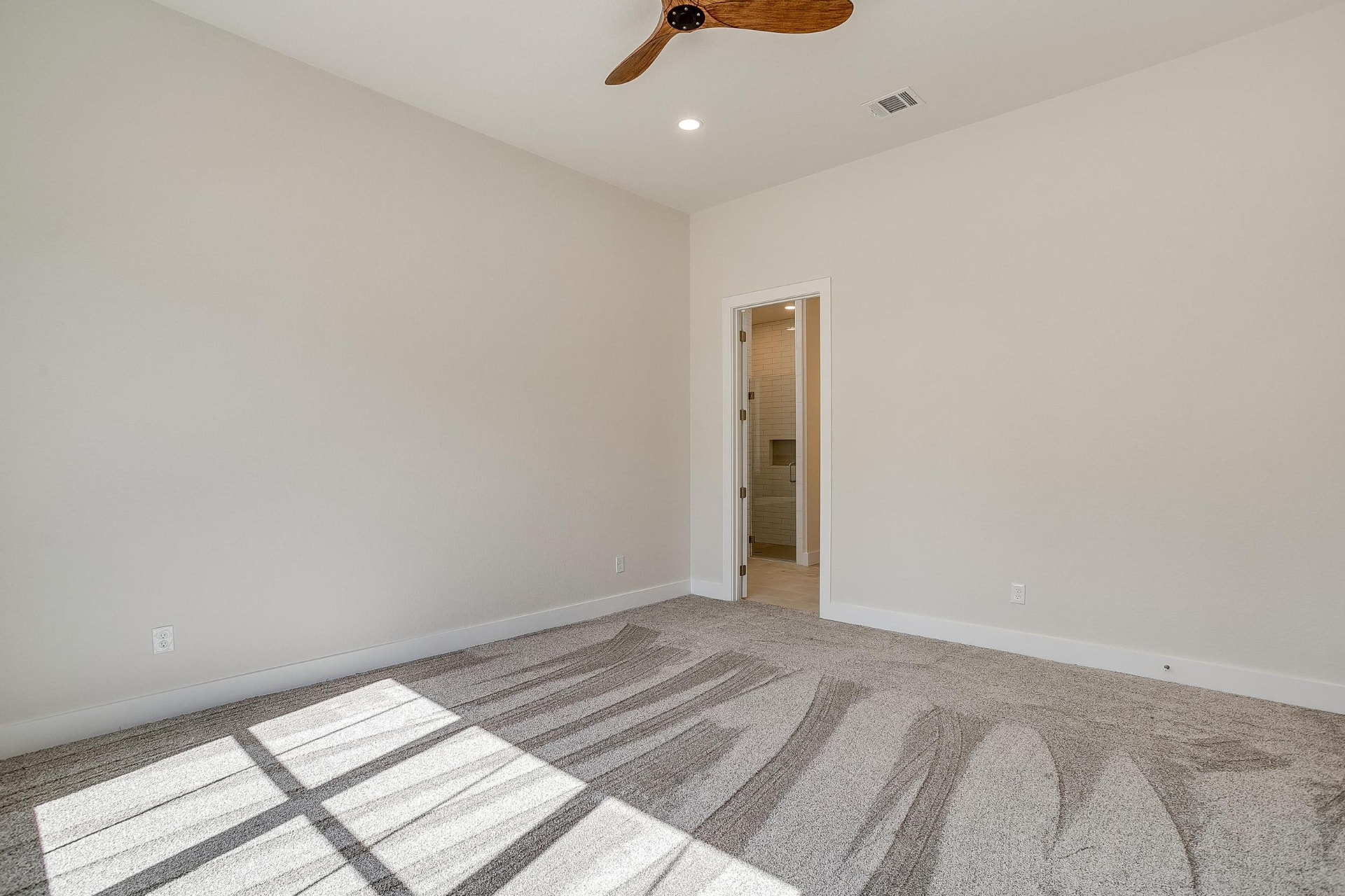 Primary bedroom suite with clean lines and a wood fan