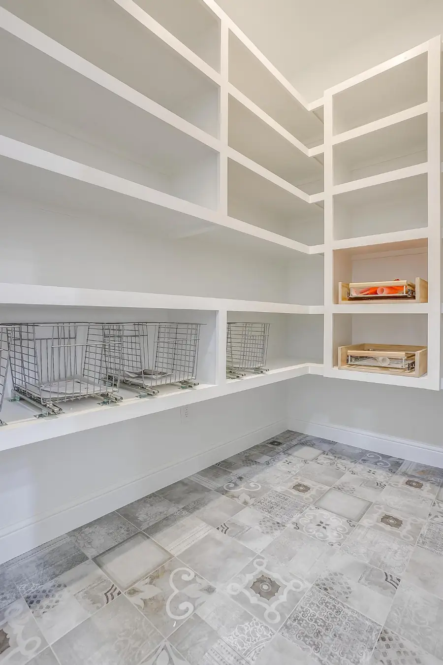 Walk-in pantry with white shelving and wire baskets