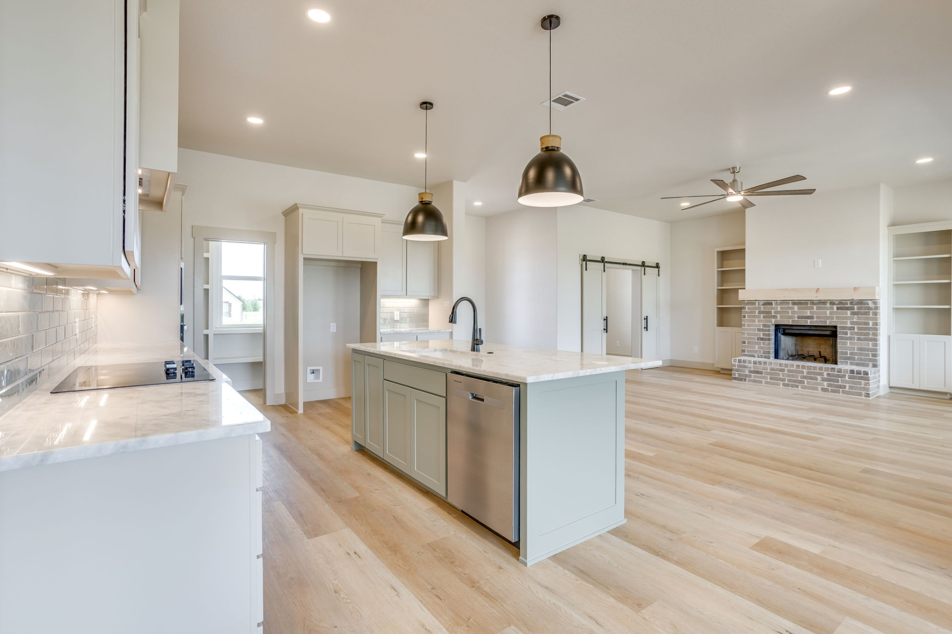 Open-concept view from the kitchen toward the brick fireplace