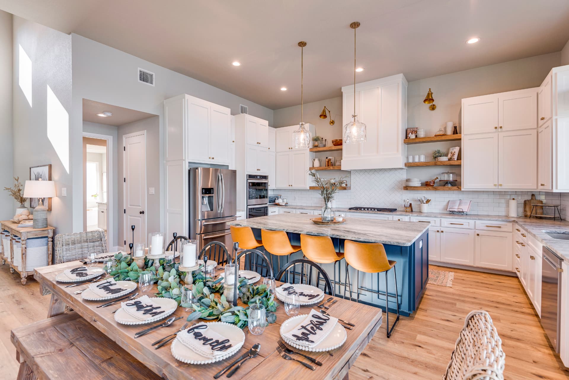 Kitchen with white cabinetry, marble-topped blue island, and gold fixtures