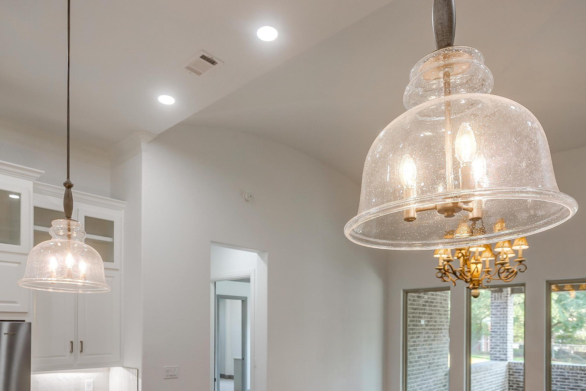 Detail of a clear glass pendant light over the island
