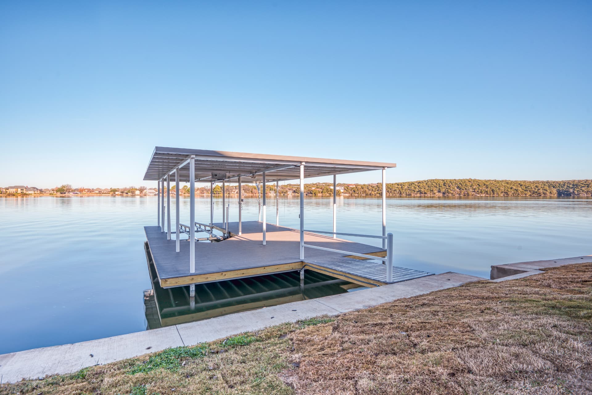 Private boat dock on calm lake water at sunset