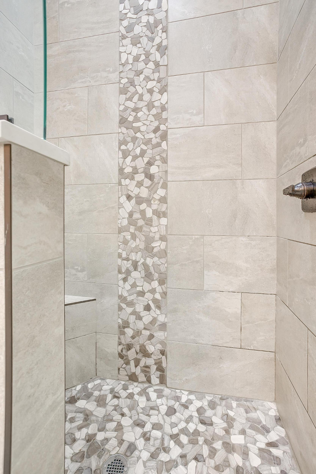 Tiled shower with pebble stone flooring