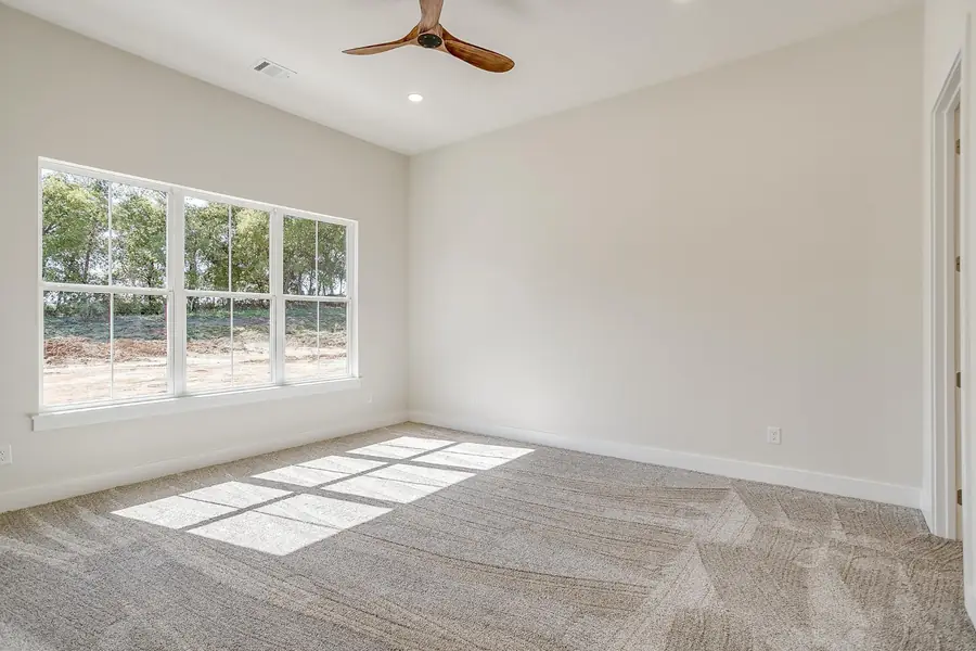 Bedroom with large windows, plush carpet, and a wood ceiling fan