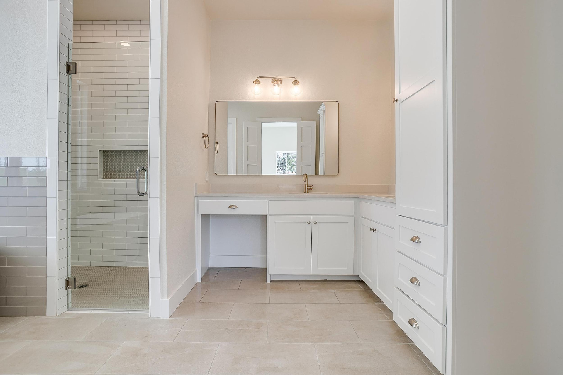 Primary bath with a long vanity and glass-enclosed shower