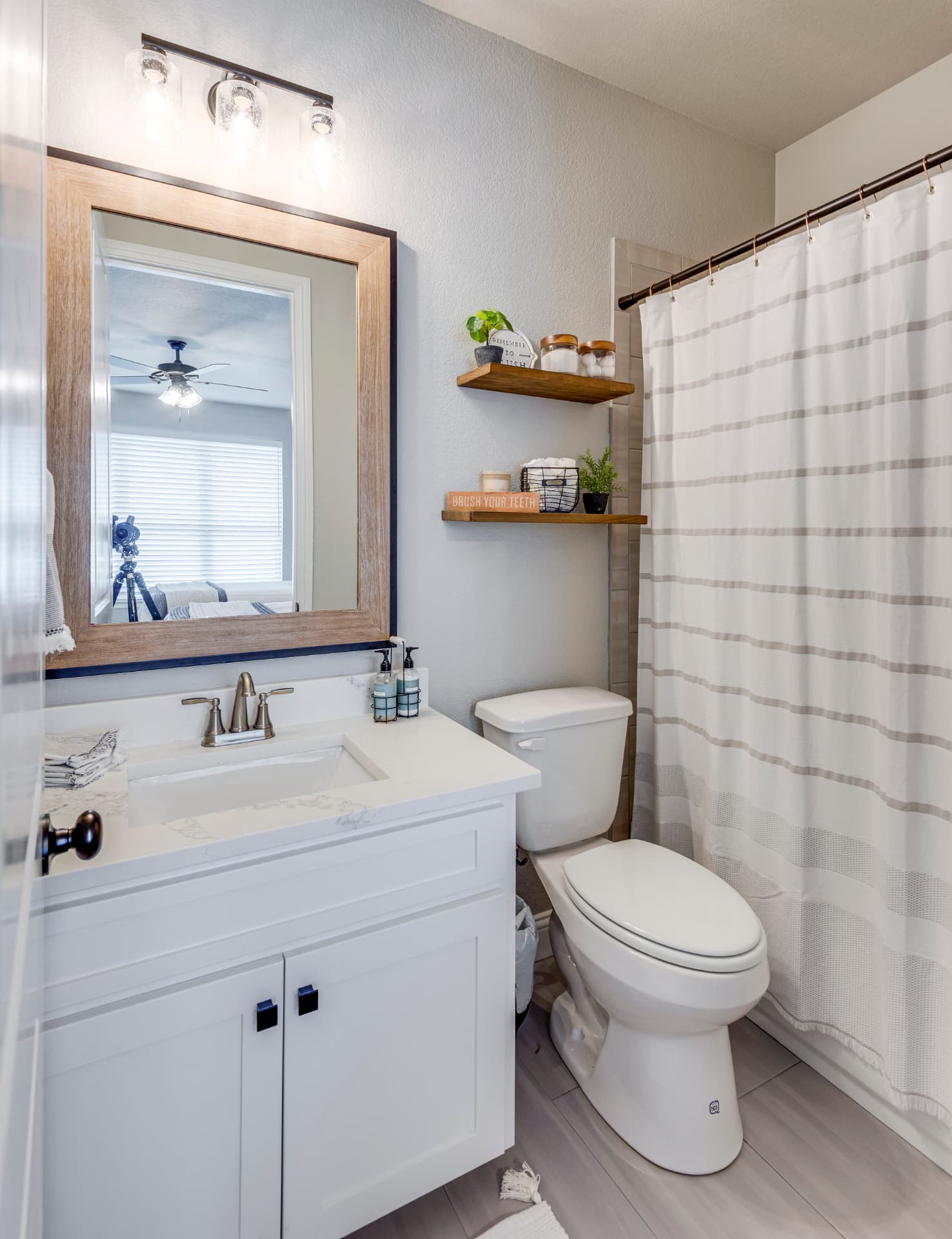 Guest bathroom with single vanity and striped shower curtain