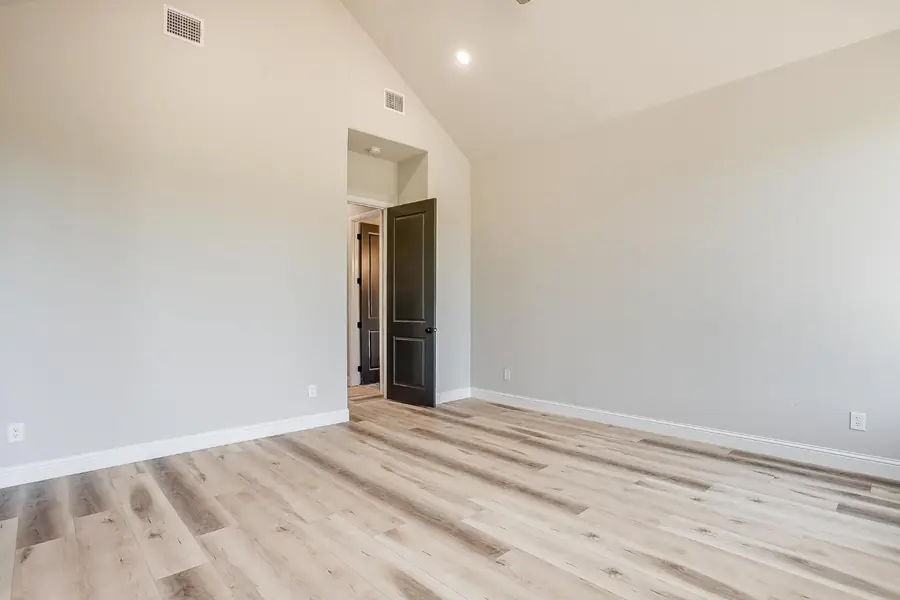 Bedroom with high ceilings and dark gray door