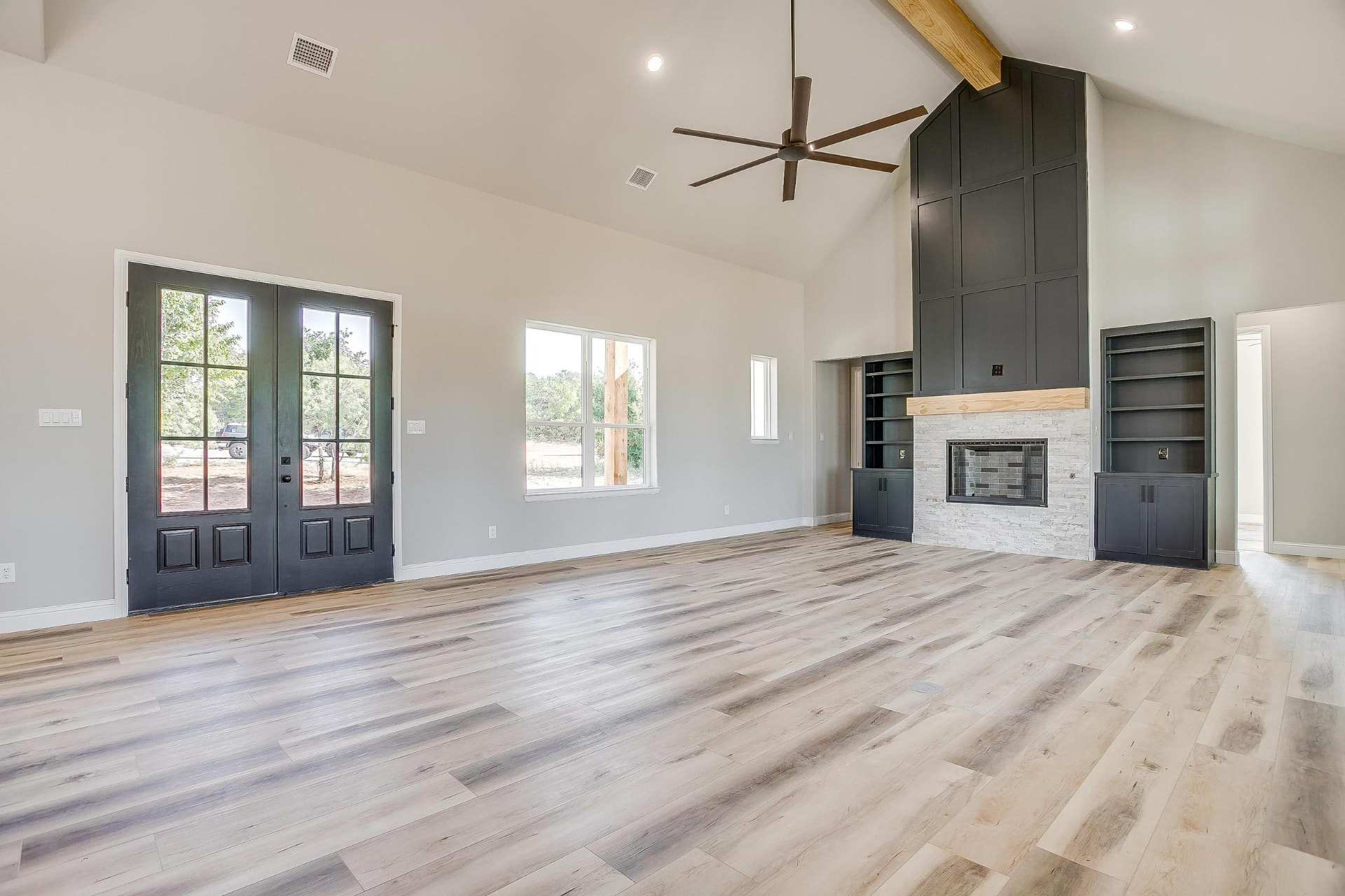 Great room with double dark entry doors and tall windows