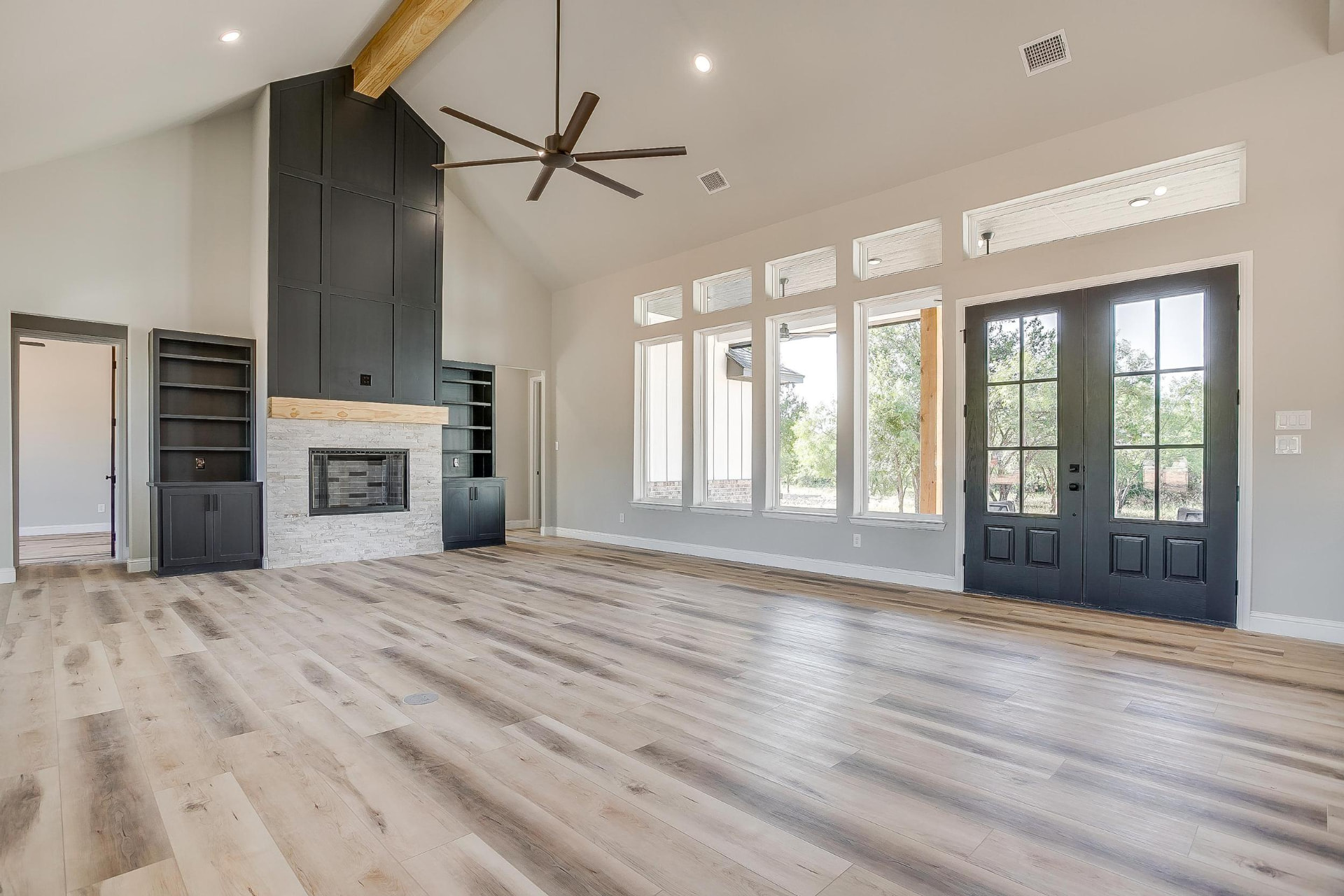 Open great room with vaulted ceiling and stone fireplace wall