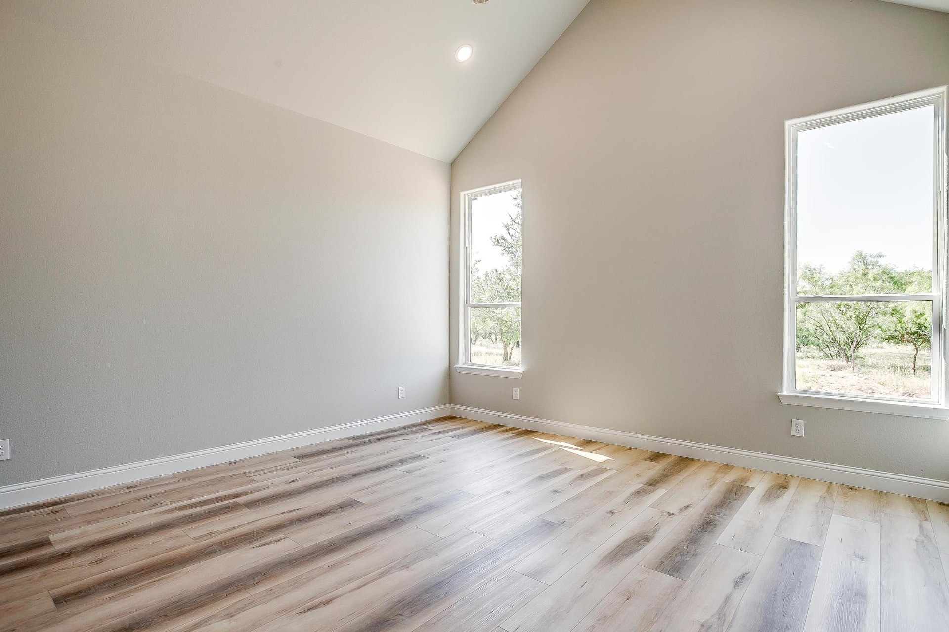 Corner of a bright bedroom with a tall window