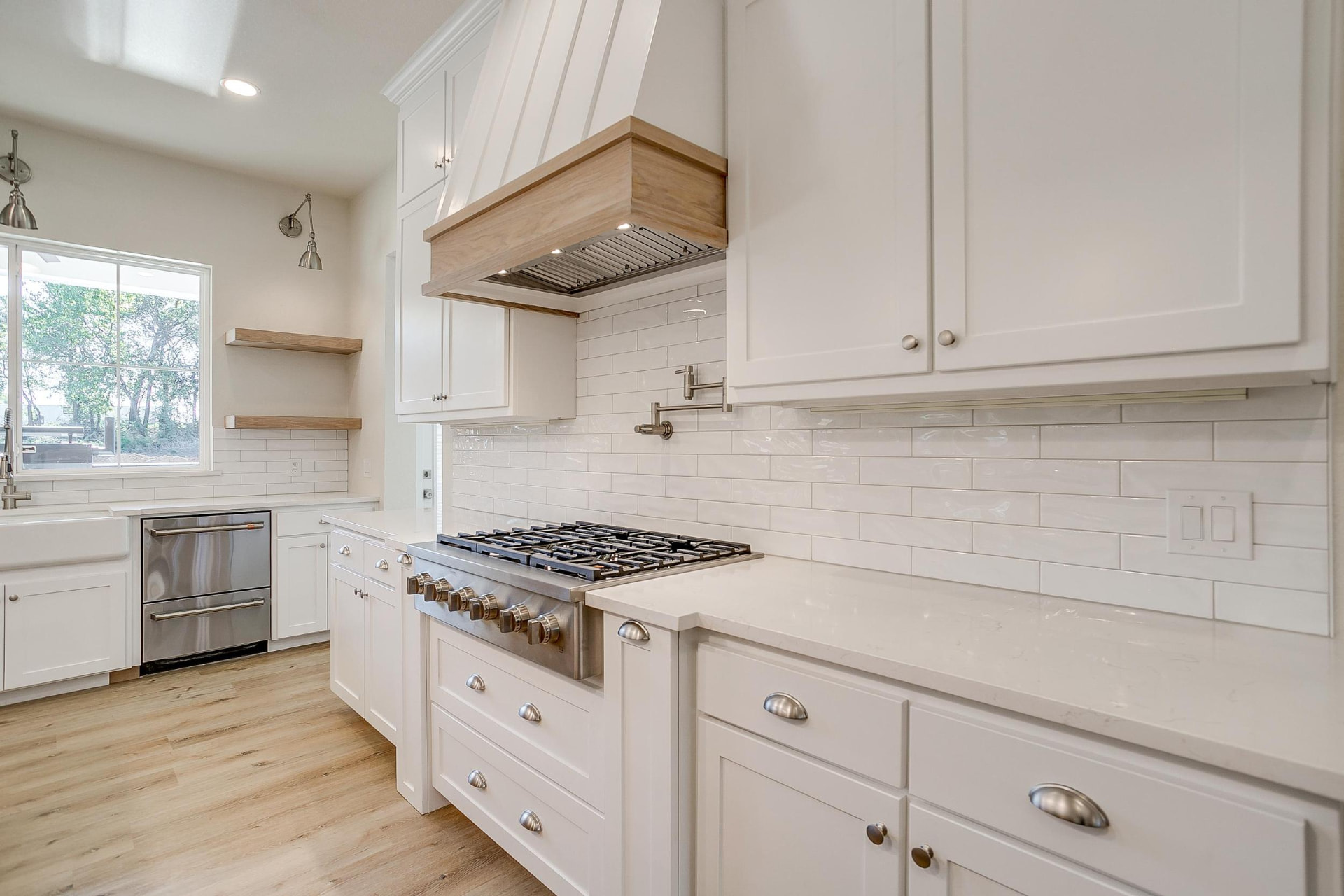 Gas cooktop with white cabinetry and polished cup pulls