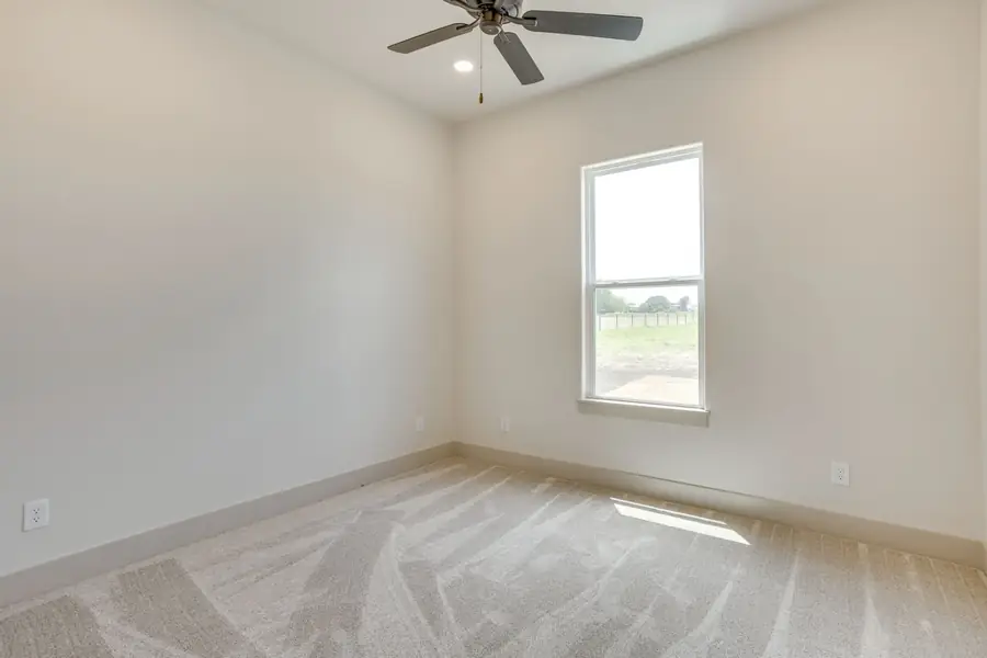 Bedroom with plush carpet and a ceiling fan