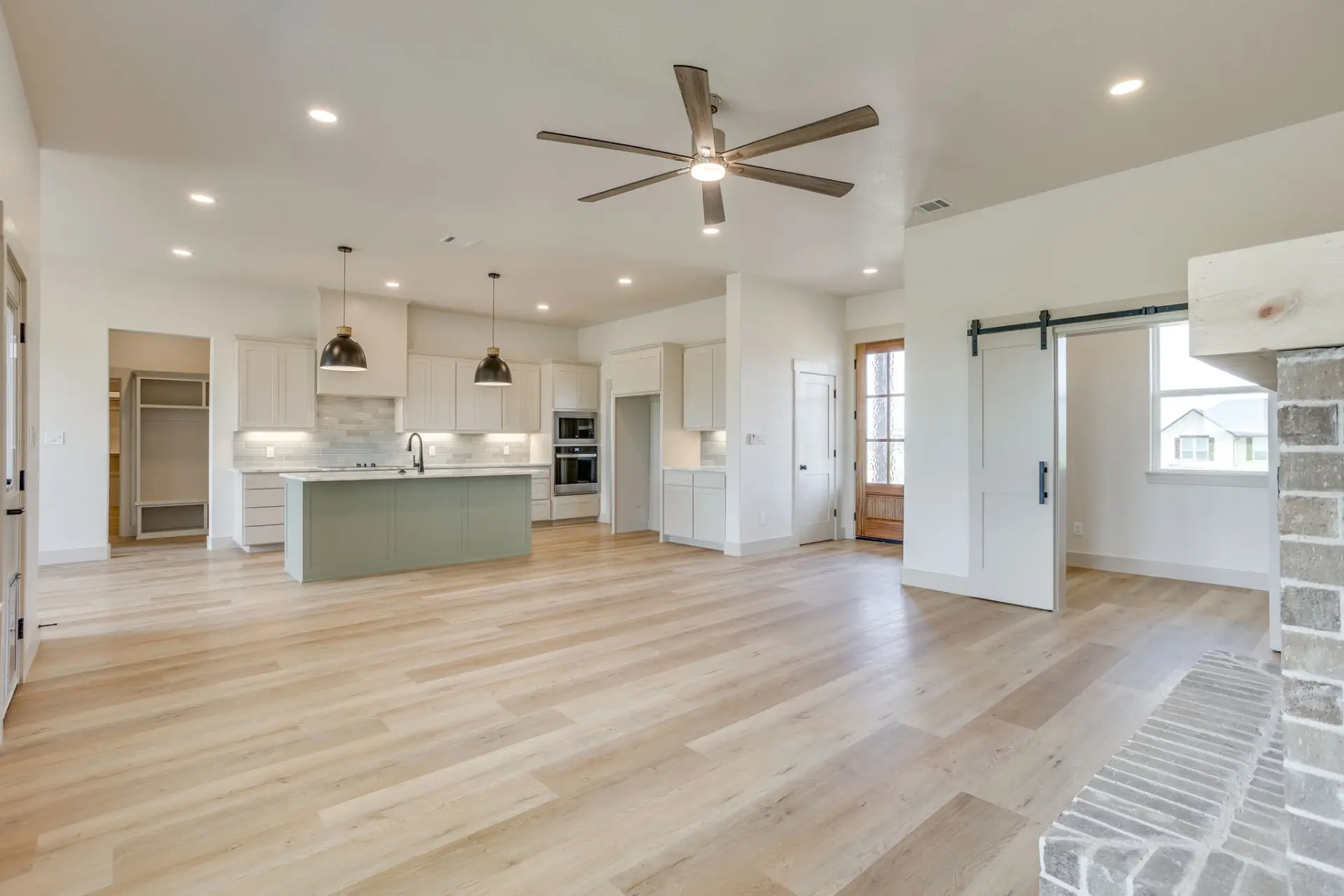 Great room opening to the kitchen with a sage green island