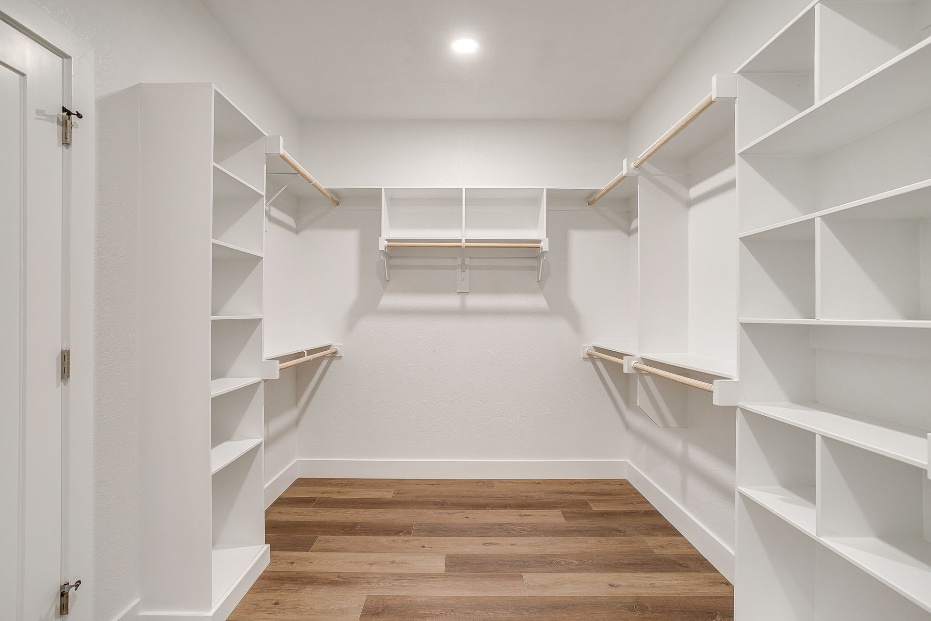 Large primary walk-in closet with floor-to-ceiling built-ins