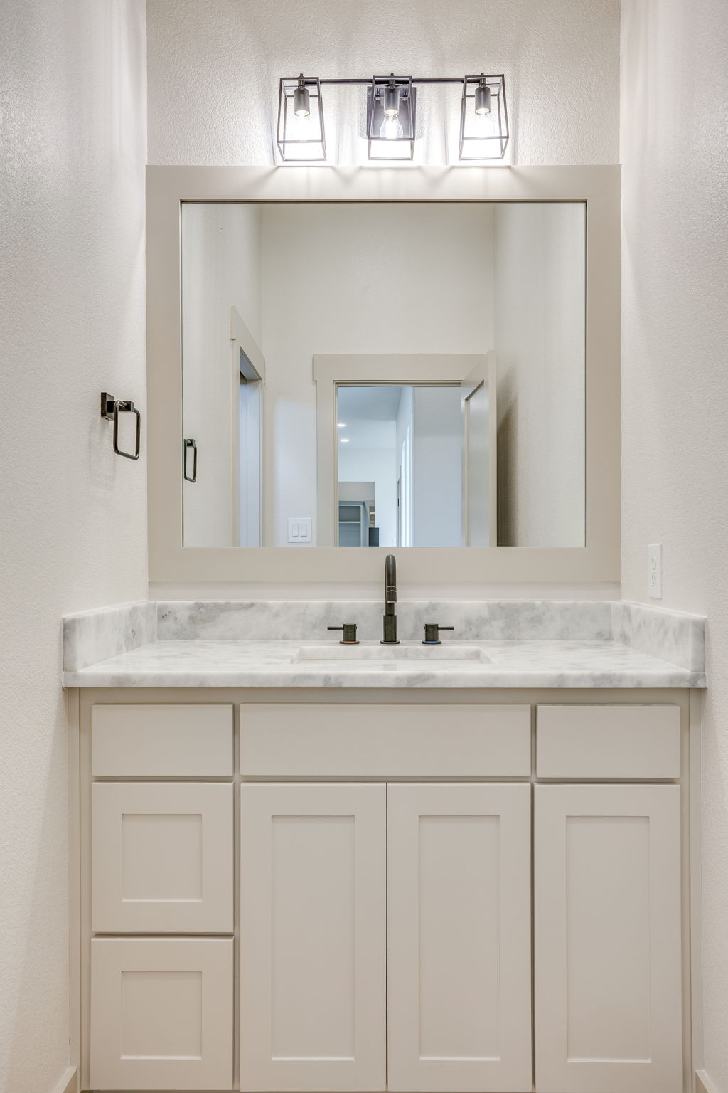 Guest vanity with marble counters and bronze fixtures