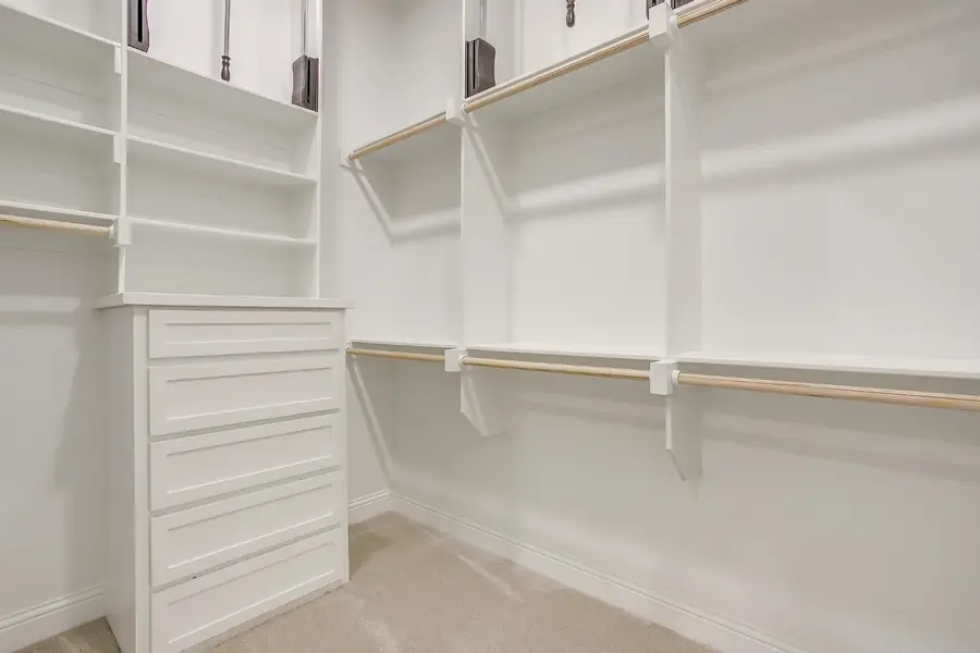 Second walk-in closet with built-in drawer tower and shelving