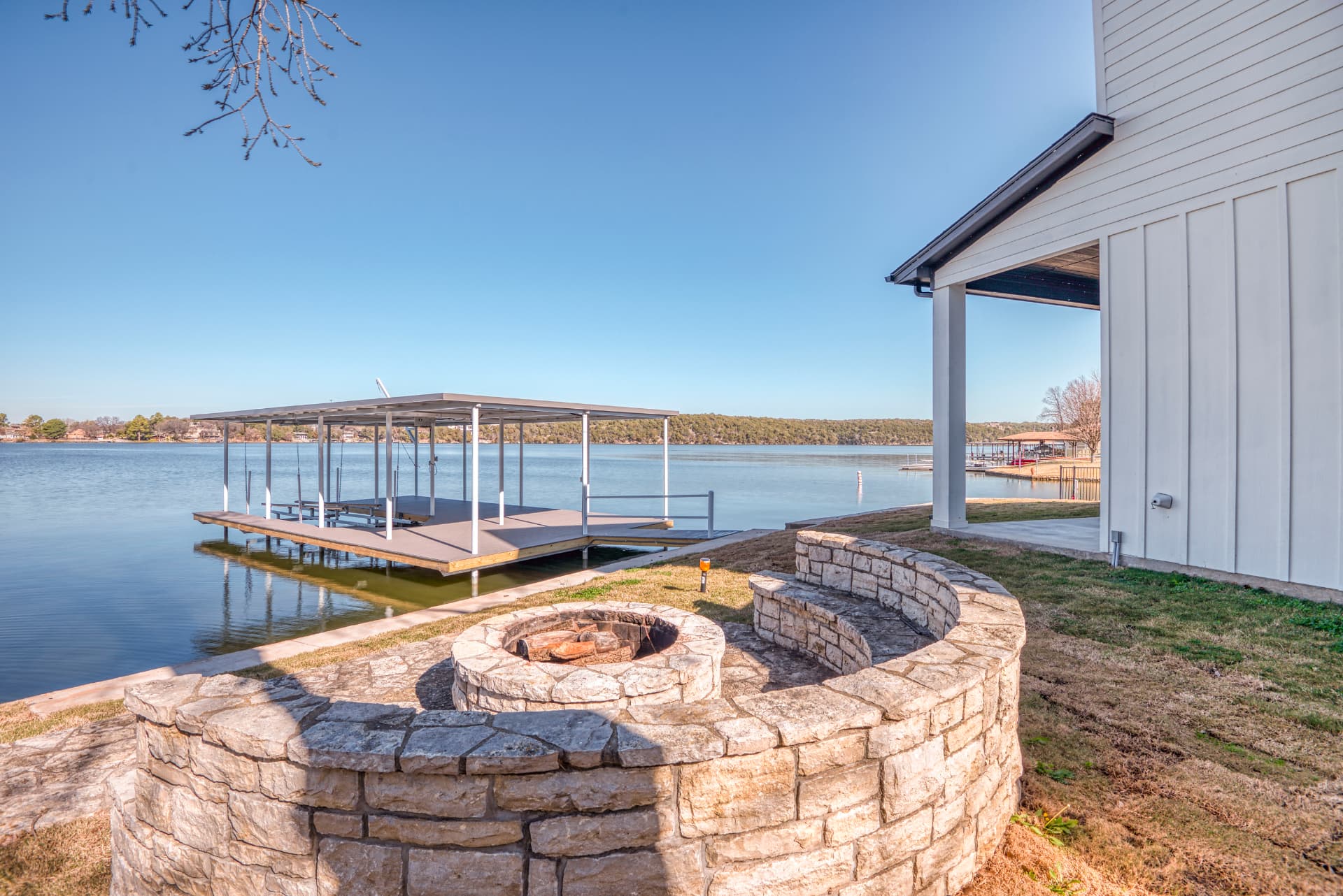 Lakeside fire pit with stone seating overlooking the dock