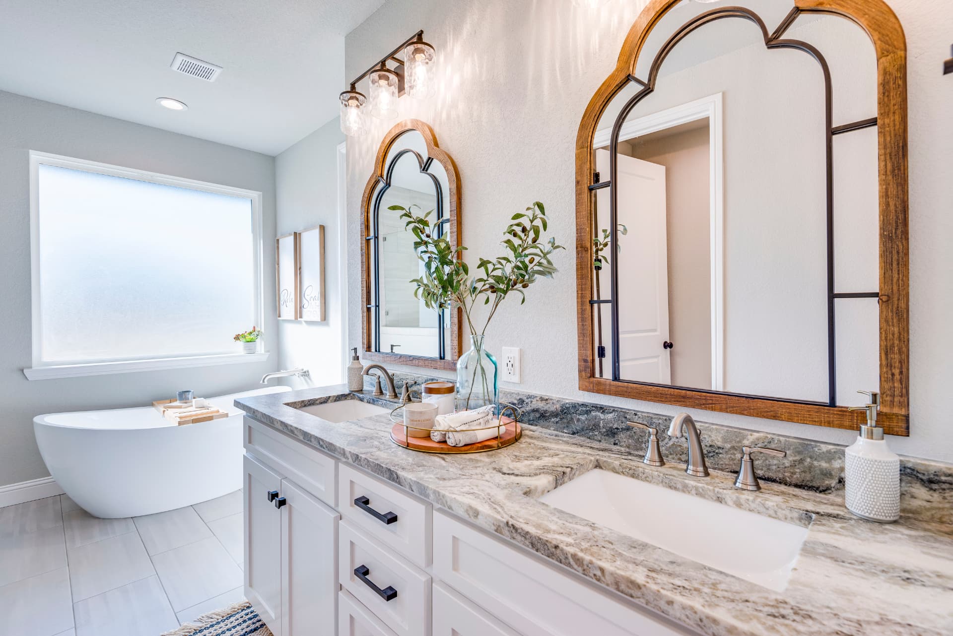 Bathroom double vanity with marble tops and wood-framed mirrors