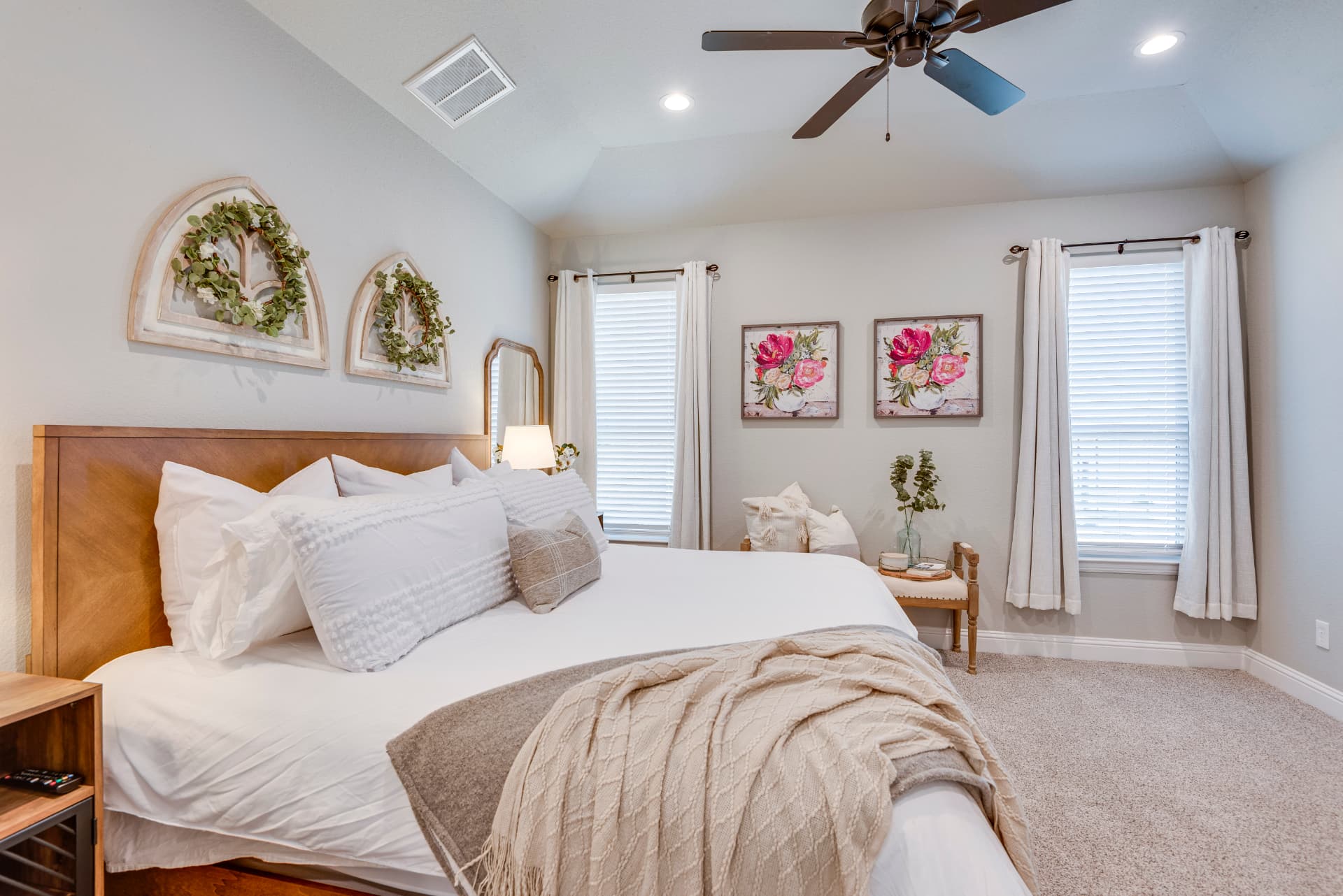 Primary bedroom with wood headboard and arched window decor