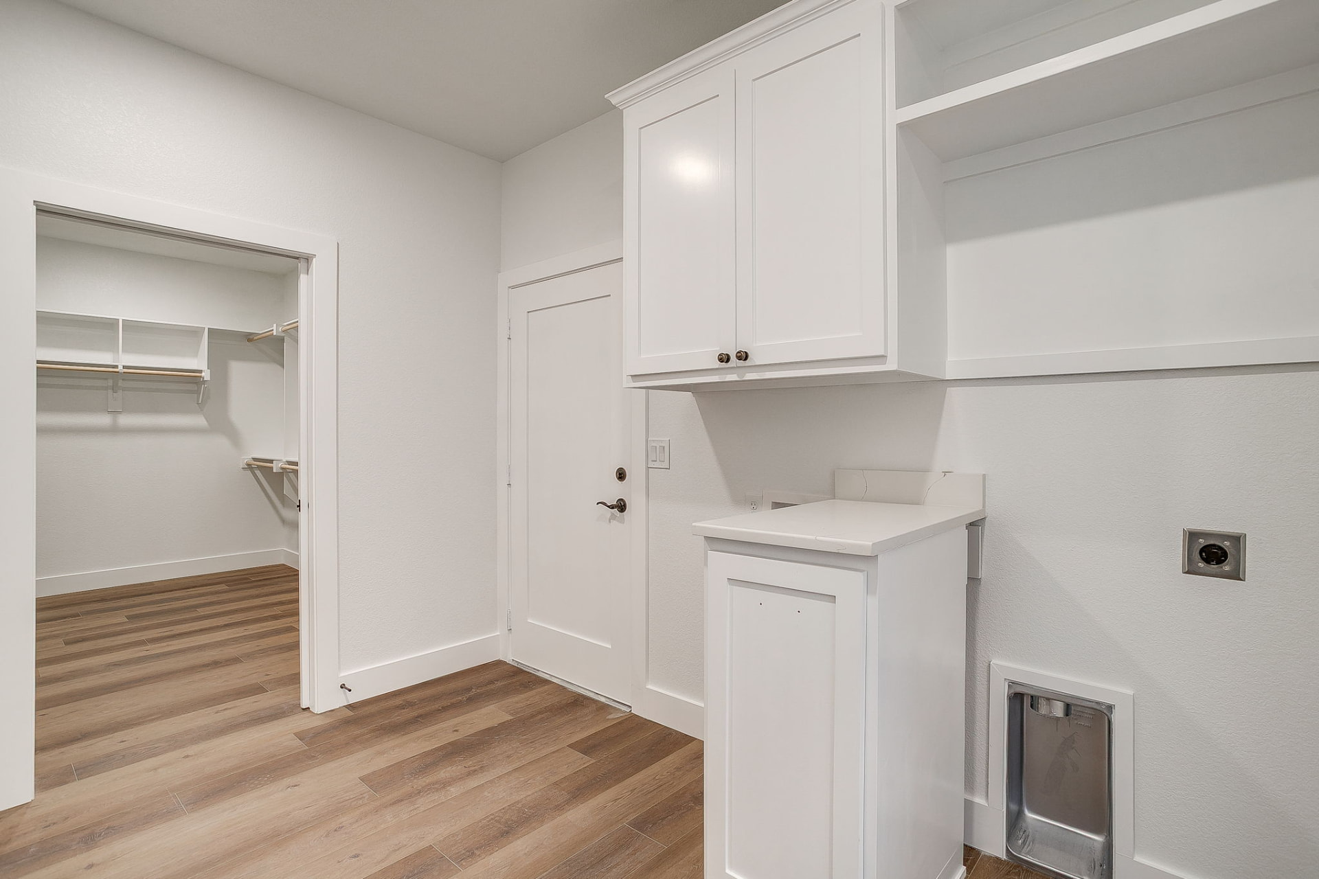 Laundry room with cabinetry, folding counter, and closet access