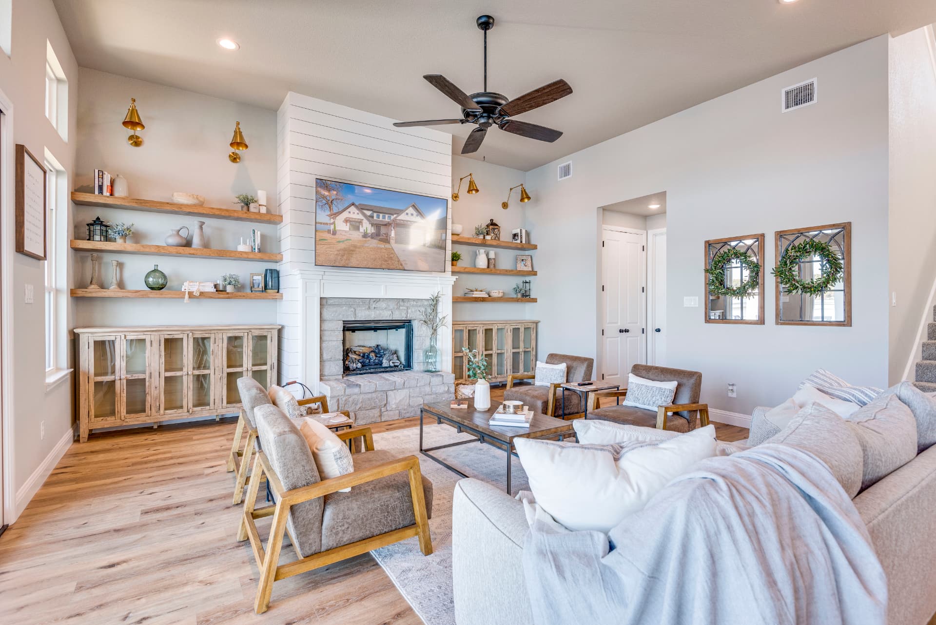 Living room with shiplap fireplace, built-in shelving, and mounted TV