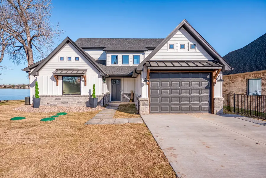 Front elevation with driveway, garage, and manicured lawn