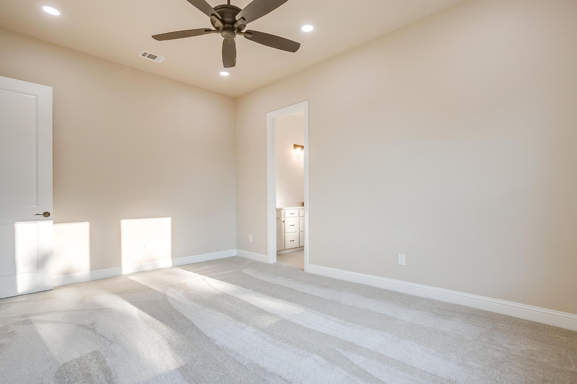 Bright bedroom with sunlight across the carpet