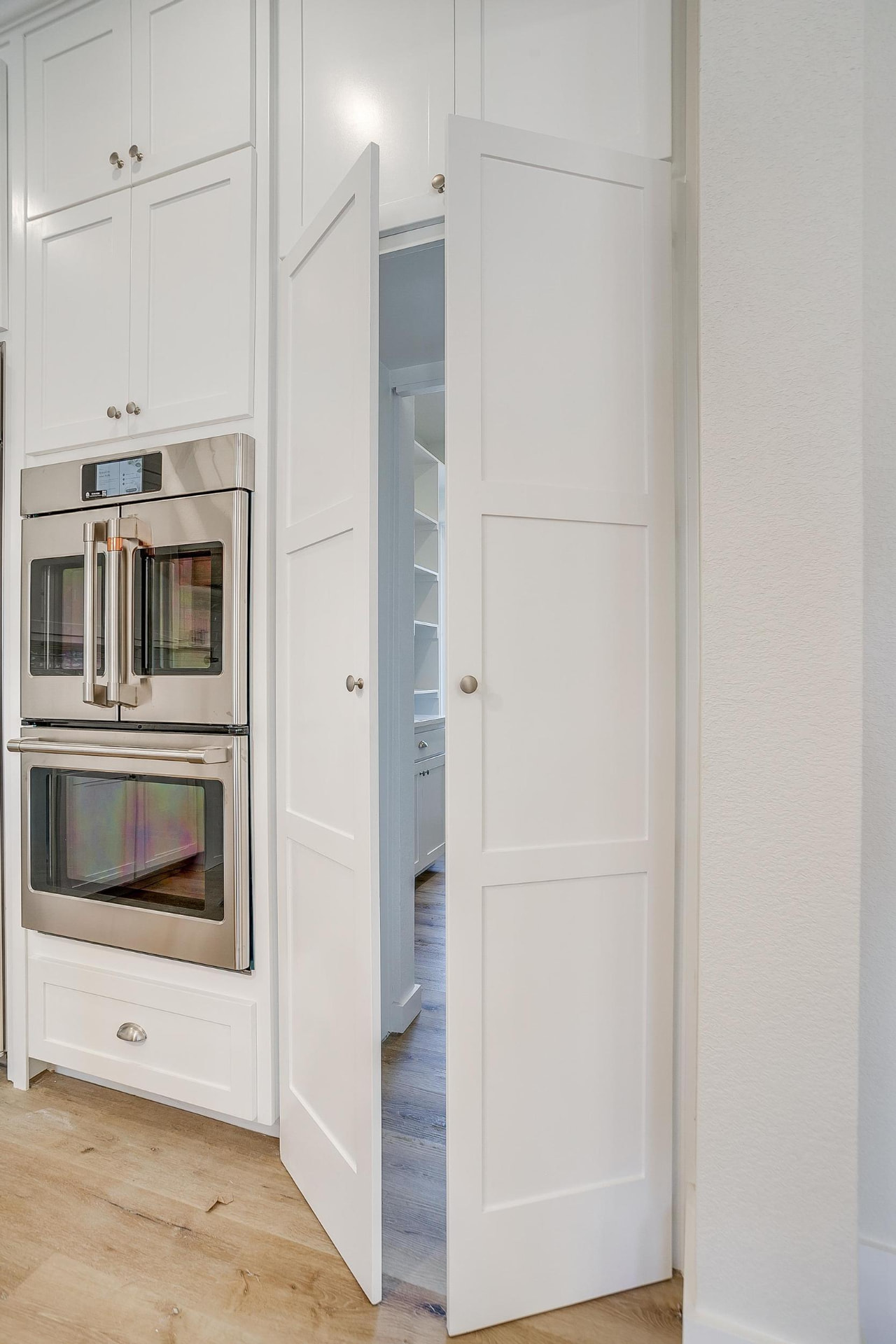 Walk-in pantry with white shelving