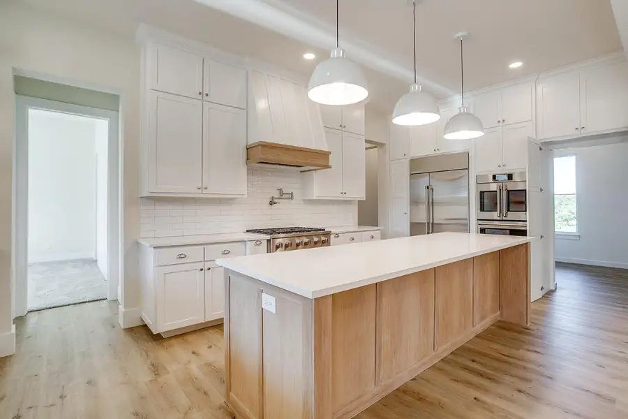 Kitchen with built-in stainless refrigerator and double ovens