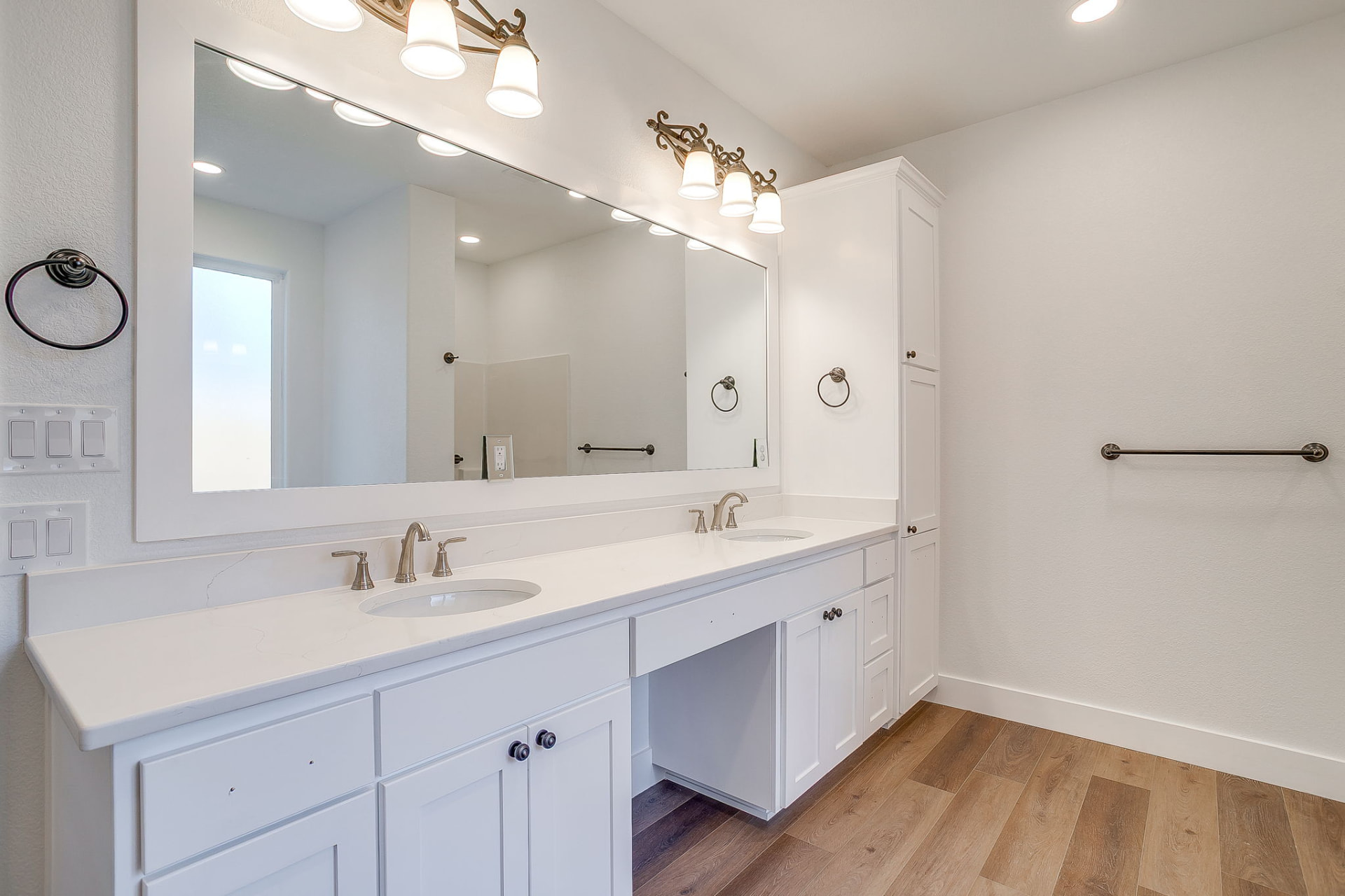 Primary bath double vanity with framed mirror and linen tower