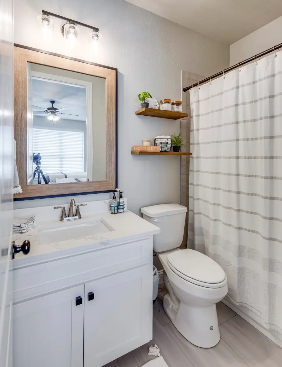 Guest bathroom with single vanity and striped shower curtain