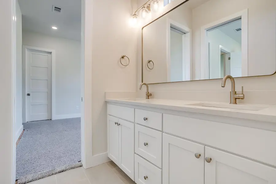 Bright guest bathroom with two sinks and neutral tile