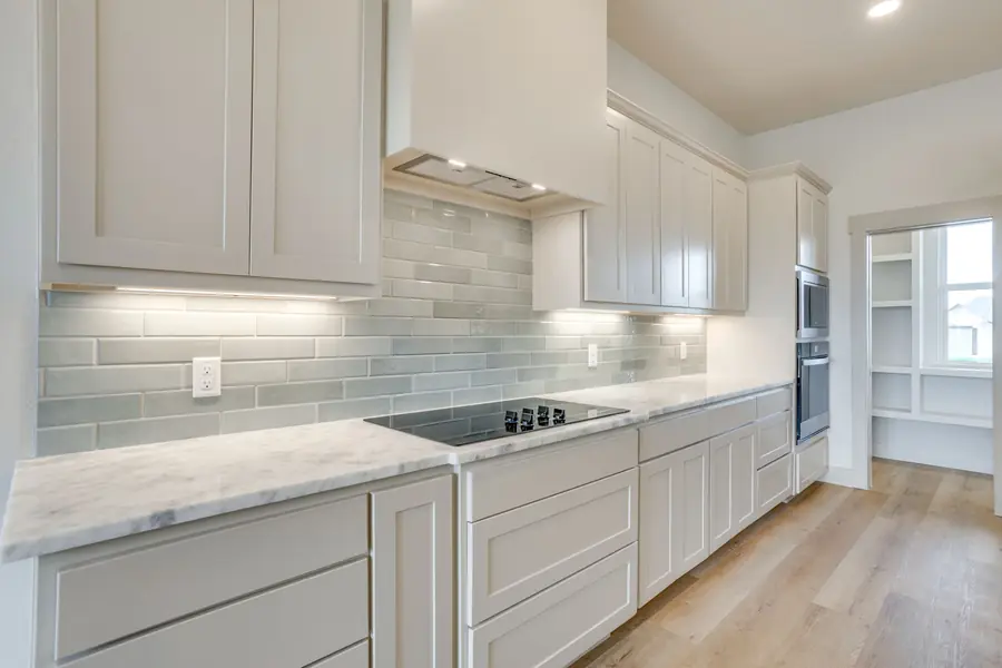 Kitchen stovetop with gray subway tile backsplash