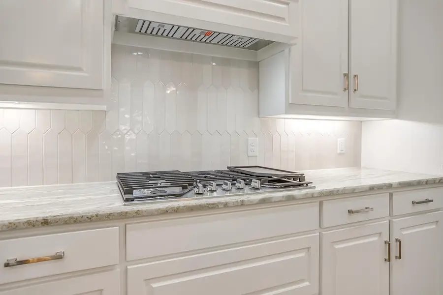Gas range with white subway tile backsplash
